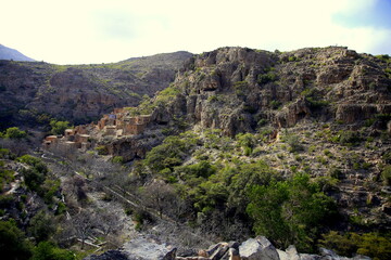 Rocky landscape with small village settled on the mountain, between two valleys, in the Jabal Akhḍar region, Oman