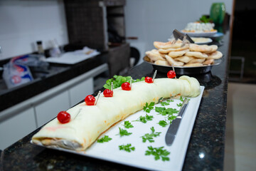 Mesa de buffet com várias opções de pratos. Foto feita em um evento social.