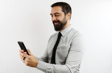 A businessman in shirt and tie types on smartphone with smiling face on white background. Bisness concept