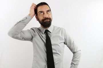 A bearded businessman, on a white background, is scratching his head thinking about an idea. Business concept