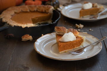 Homemade pumpkin pie baked in cast iron pan, on wooden background