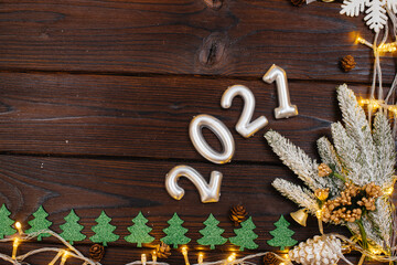 The wooden Christmas background is decorated with festive decor, lanterns, snowflakes and branches of the Christmas tree. Christmas card. Winter holiday season. Happy New Year.