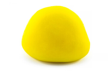 A macro shot of a hard coated yellow candy, isolated on a white background.