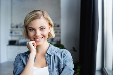 portrait of smiling blonde woman at home