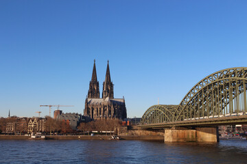 The Hohenzollern bridge over Rhine river on a sunny day. The Cologne Cathedral (Kolner Dom) in the city of Cologne, Germany. It is the largest Gothic church in northern Europe.