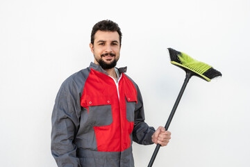 Hardworking man with a beard carries a broom. Sweeper occupation