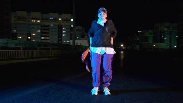 Beautiful young dancer dancing hip hop, street dance at night outdoors. Youth lifestyle and emotions concept. Gimbal shot