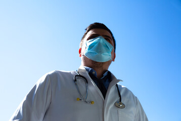Doctor in medical mask outdoors. Treatment during pandemic of coronavirus.