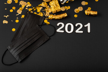 2021 text lettering with black medical face masks, gold Christmas festive decor. Protective face surgical masks in Celebrating New Year composition covid 19 Coronavirus. Copy space