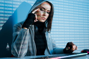 Internet, crime, cyber attack, system breaking concept. Blue neon light background. Woman hacker is working on a code with digital interface all around.