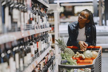 African woman with shopping cart. Girl in a supermarket.