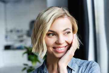 portrait of smiling blonde woman looking out window