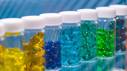 Colorful medical capsules, pills, vitamins, tablets, drugs, meds in clear plastic bottle for sale at pharmacy drug store, pharmaceutical exhibition. Pharma industry, medicine and healthcare concept
