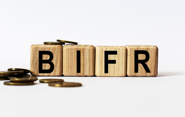 wooden cubes and BIFR, coins, the concept of taxation, increase taxes and fees