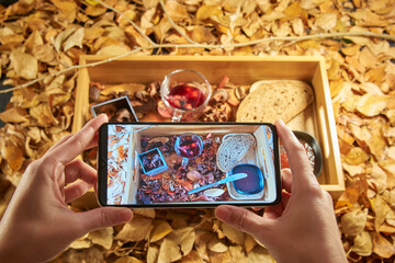 Hands taking a photo of a healthy breakfast with red tea