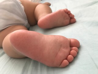 little pink baby feet in bed 