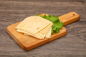 Sliced yellow cheese over board