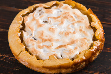 Pear pie with cream, homemade pastries on wooden table. Copy space.