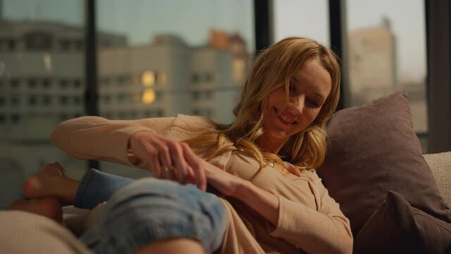 Happy mom and kid fooling around at home. Woman and child having fun on couch.