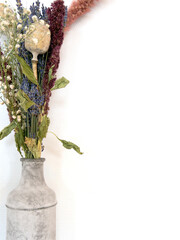 Gray concrete vase with bright dried bouquet flowers in front of the white wall modern decoration of home, copy space