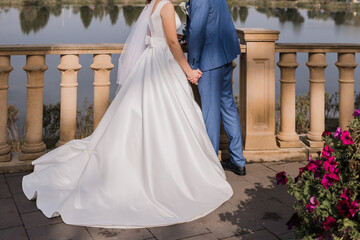 Fototapeta premium bride and groom near the railing on the embankment