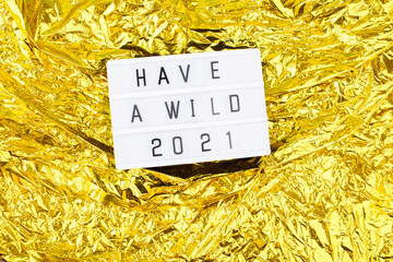 Light box with an inscription have a wild 2021 on a bright gold background.