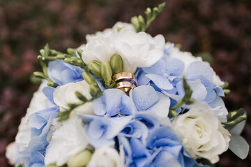 Fototapeta na wymiar bridal bouquet of flowers with gold wedding rings