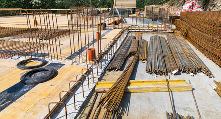 Bundles of steel rebar rods and grids into reinforced cement concrete at a building site. Ferroconcrete reinforcing bars for ceiling and floor slabs or walls. Metal rusty wires. Construction industry.