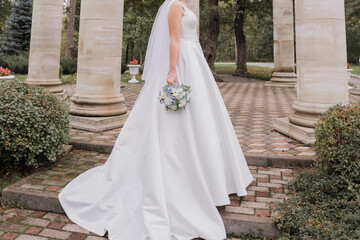 bride in a wedding dress in columns in the park