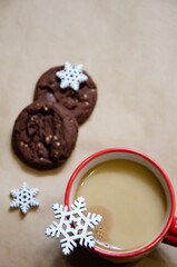 Obraz na płótnie Canvas Cup of coffee on a blurred background with chocolate cookie and decorative snowflakes. Selective Focus, top view, flat lay. Christmas composition background with copy space. Christmas concept.