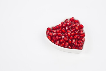 Pomegranate seeds in heart shape plate 