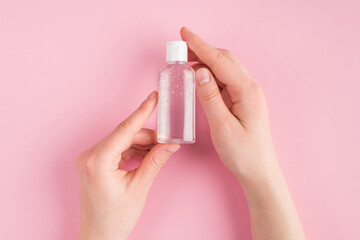 Top above overhead close up pov first person view photo of female holding gel sanitizer isolated on pink pastel background with copyspace