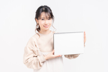 Fototapeta premium 小さいスケッチブックを持つ若い女性