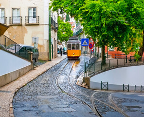 The vintage yellow tram in the narrow curved street, Lisbon, Portugal