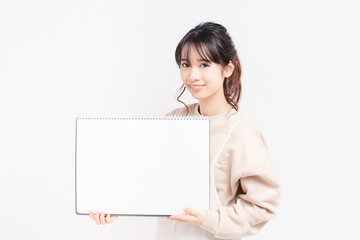 Fototapeta premium 大きいスケッチブックを持つ若い女性