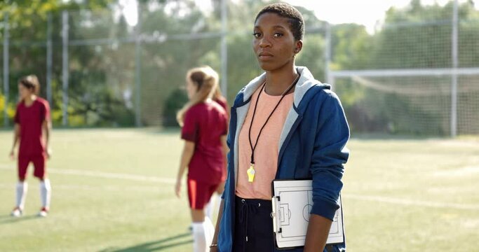 African-american female soccer coach stading in soccer team practice