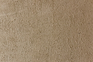 The surface of the wall, plastered in light brown.