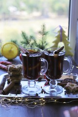 
Traditional Christmas drink, cups with mulled wine, spices, fir branches, Christmas toys and illumination on a dark background, celebration concept, home comfort, winter
