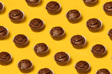 Сhocolate cupcakes or cookies pattern on a yellow background. Summer minimalism. Isometric flat lay. Top view. Food concept.
