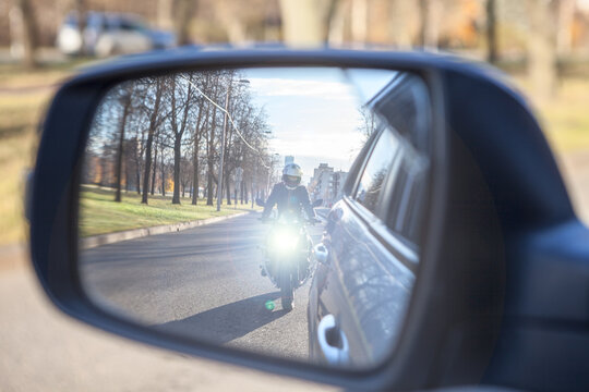 Dazzle Lighting From Riding Motorcycle In Side View Mirror Of Car. Dazzling Effect Concept