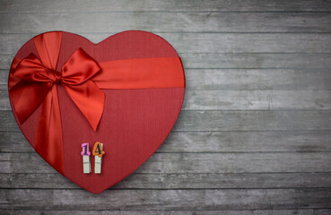 Box in the form of a red heart for Valentine's day on a wooden background