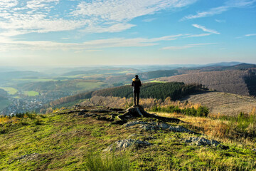 a man standing in the winter on a hill in nature