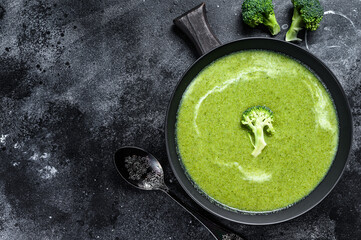 Fresh cream broccoli and pea soup in plate . Black background. Top view. Copy space