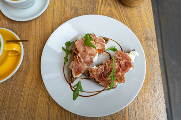 simple ciabatta slices with speck and mozzarella on wood table