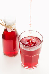Pomegranate juice in glass on white background