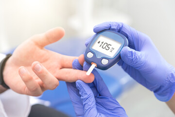 Doctor making blood sugar level test in clinic