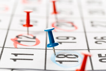 Fototapeta premium Thumbtack in calendar concept for busy, appointments and meeting reminders