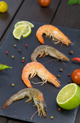 shrimp on a stone plate, black allspice and lime around