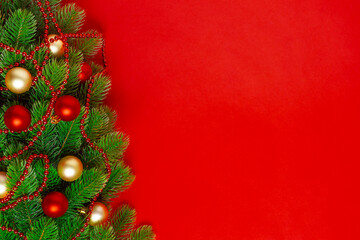 Christmas tree branches greeting card with red and Golden balls, a garland of beads on a rich background, mock up.