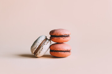 Tasty french macaroons on a pink pastel background.